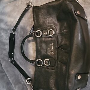 Black coach bag with silver hardware and purple lining